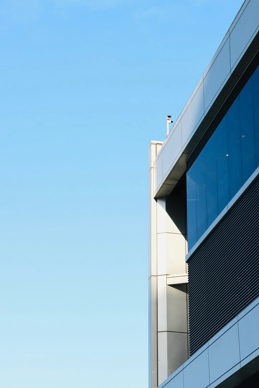 A worker cleaning skyscraper windows with a harness in an urban setting.